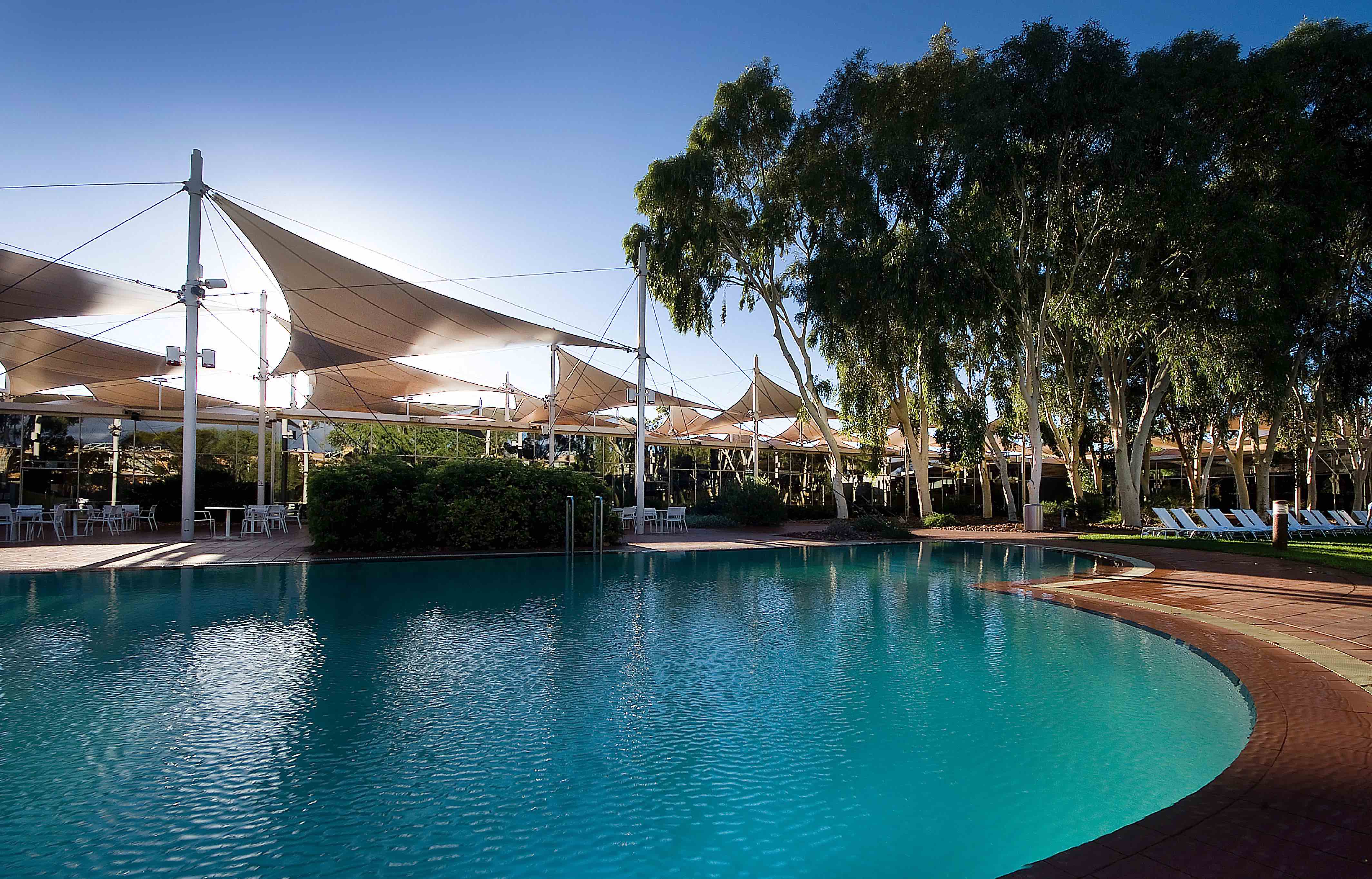 Pool surrounded by lounge chairs and outdoor bar