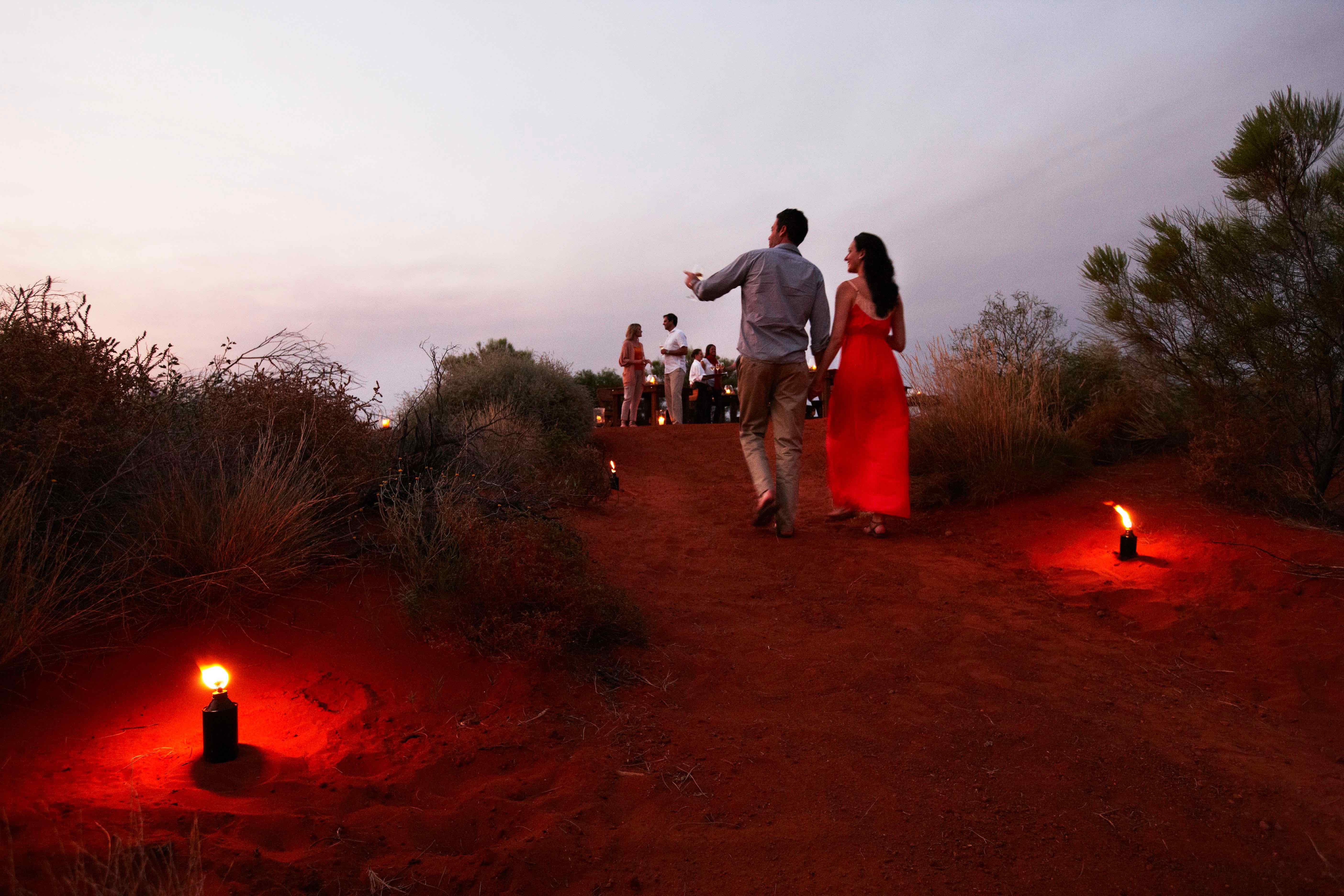 couple on red sand pathway at Ayers Rock resort