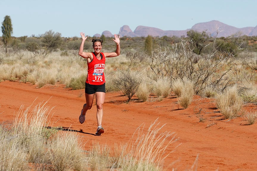 A Woman smiles while running in the Australia Outback Marathon