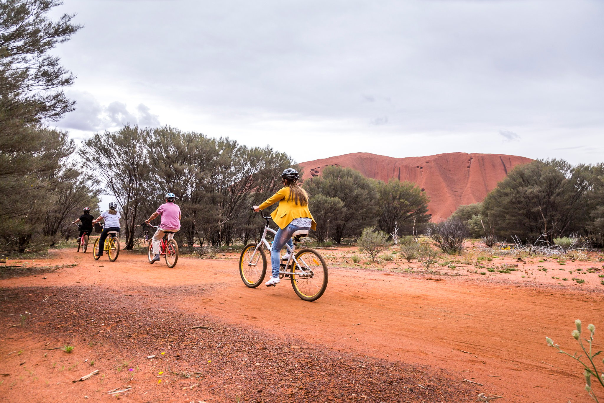 people cycling by Uluru