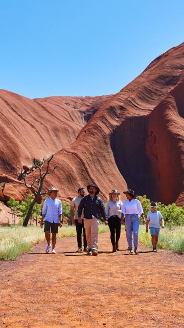 People walking on the Desert Awakenings Tour around Uluru